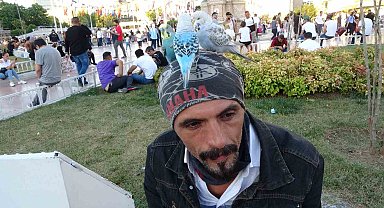 Başında gezdirdiği 3 muhabbet kuşuyla Taksim'de ilgi odağı oldu