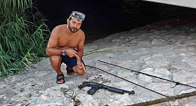 Madeni para için daldığı çayın dibinden pompalı tüfekle çıktı