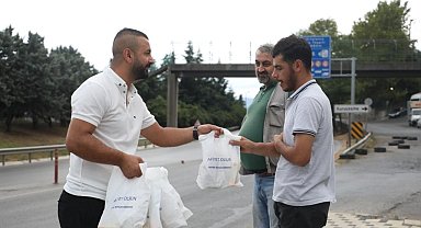 Servis bekleyen işçilere poğaça dağıtılıyor