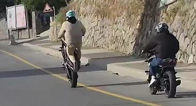 Akrobasi hareketleri yaparak motosiklet kullanan şahıs kamerada